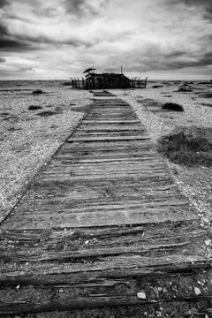 Concept image of path to nowhere in desolate beach black and white landscape Stockfoto's
