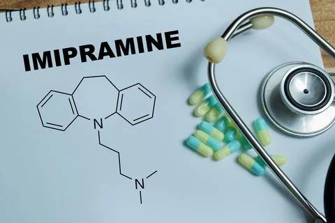 Concept of imipramine medication write on book isolated on Wooden Table. Stock Photos