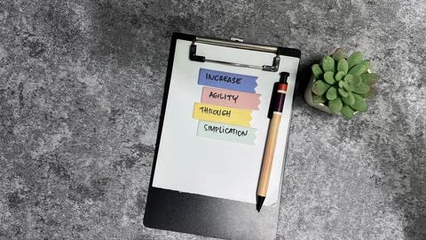 Concept of Increase Agility Through Simplication write on sticky notes Stock Photos