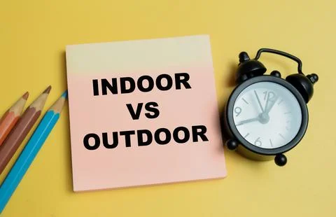 Concept of indoor vs outdoor write on sticky notes isolated on table. Stock Photos