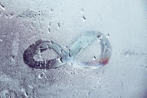 Concept with an infinity sign on a wet window Stock Photos