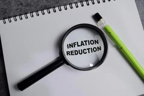 Concept of Inflation reduction write on book isolated on Wooden Table. Stock Photos