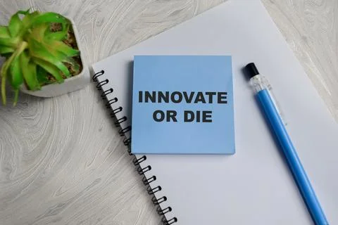Concept of Innovate or die write on sticky notes isolated on Wooden Table. Stock Photos