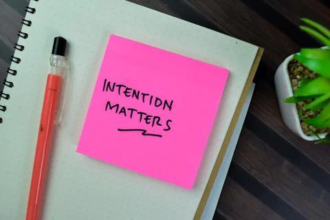 Concept of Intention Matters write on sticky notes isolated on Wooden Table. Fotos de archivo