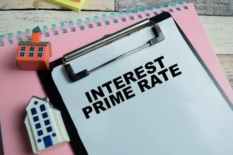 Concept of interest prime rate write on clipboard isolated on Wooden Table. Stock Photos