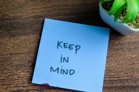Concept of Keep in Mind write on sticky notes isolated on Wooden Table. Stock Photos