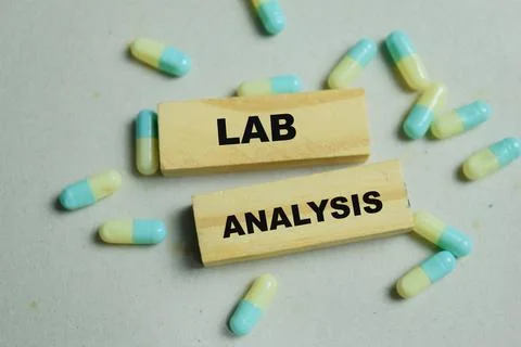 Concept of lab analysis with pills text on wooden blocks. Stock Photos