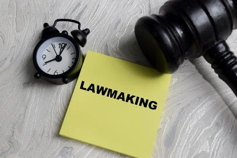 Concept of law making write on sticky notes isolated on Wooden Table. Stock Photos