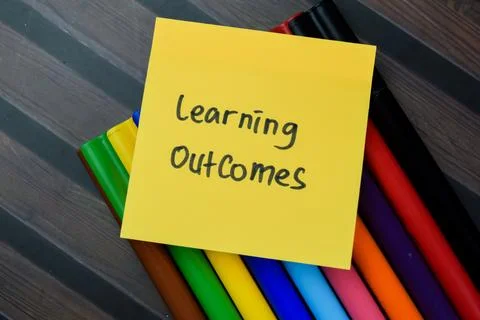 Concept of Learning Outcomes write on sticky notes isolated on Wooden Table. Stock Photos