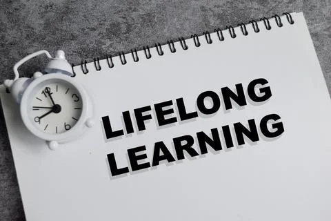 Concept of lifelong learning write on book isolated on Wooden Table. Stock Photos