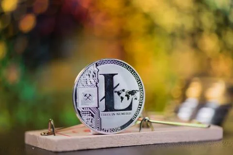 Concept of litecoin in a  mouse trap. Risks and dangers of investing in the c Stock Photos