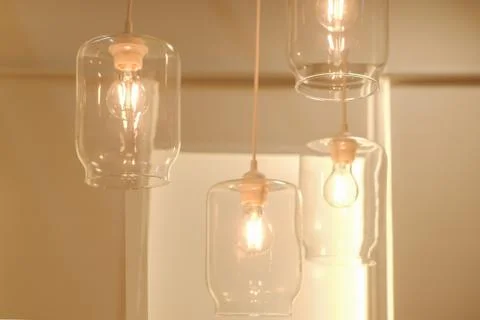 Concept loft style, underground style. Four glass electric lamps burn in a br Stock Photos