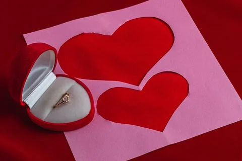 Concept of love note, proposal with cut out hearts and wedding ring Foto stock