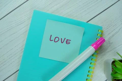 Concept of Love write on sticky notes isolated on Wooden Table. Stock Photos