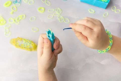 Concept of making loom bracelets by kids blue and yellow Stock Photos