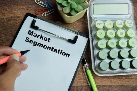 Concept of market segmentation write on clipboard isolated on Wooden Table. Stock Photos