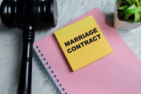 Concept of marriage contract write on sticky notes isolated on Wooden Table. Stock Photos