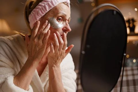 Concept of mature face skin care. Patch Application Process. Mature woman in  스톡 사진