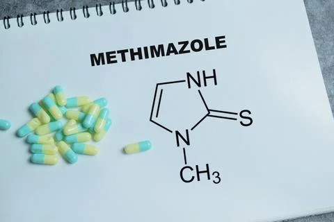 Concept of methimazole antithyroid write on book isolated on Wooden Table. Stock Photos