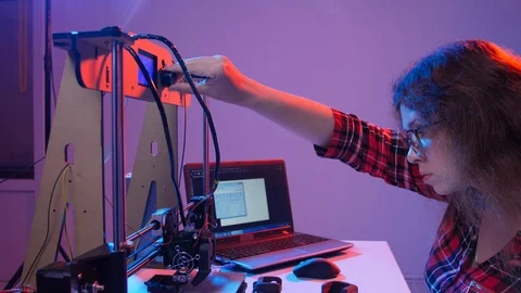 Concept of modern production technologies. Young woman prints a model on a 3D Stock Footage 116624471