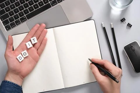 Concept of motivation and productivity with a notepad and Do It caption. Hand Stock Photos