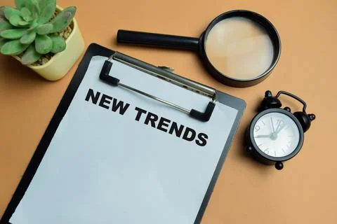 Concept of new trends write on clipboard isolated on table. Stock Photos