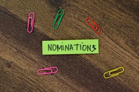 Concept of Nominations write on sticky notes isolated on Wooden Table. Stock Photos
