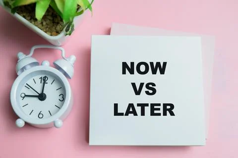 Concept of now vs later write on sticky notes isolated on table. Stock Photos