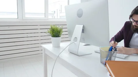 Concept of office work or freelancing. Young bearded stylish man working at the Stock Footage 99537939