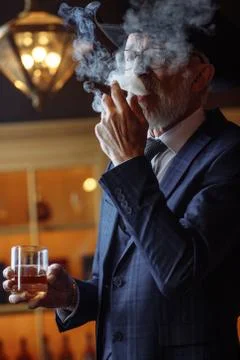 Concept of old age wisdom and experience. Old man with cigar and Stock Photos
