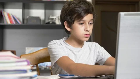 Concept of online learning. the child is enrolled in an online school. boy doing Stock Footage 82703330