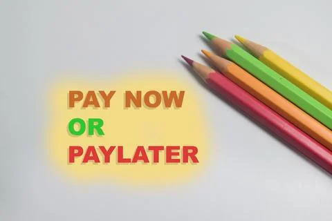 Concept of pay now or paylater write on book isolated on Wooden Table. Fotos Stock