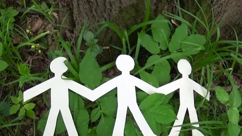 Concept of person and environment. Human figures made of paper on grass Stock Footage 77086536