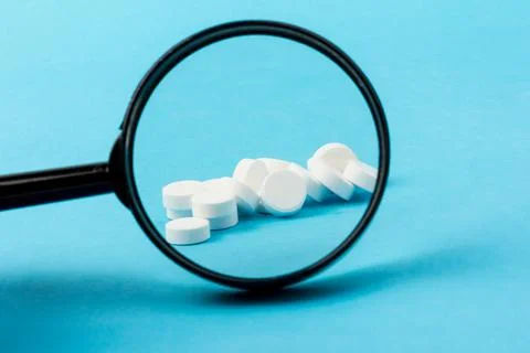 Concept - pharmaceutical testing, testing of medicines, magnifying glass, tab Stock Photos