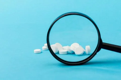 Concept - pharmaceutical testing, testing of medicines, magnifying glass, tab Stock Photos
