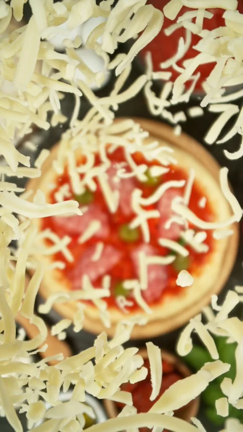 Concept of Pizza Preparation with Flying Cheese from Above. Stock Footage 309093883
