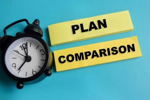 Concept of plan comparison write on sticky notes isolated on Wooden Table. Stock Photos