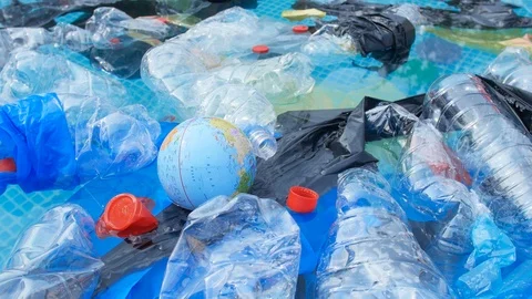 Concept of planet pollution and non-recyclable waste. A globe floating among Stock Footage 113544949