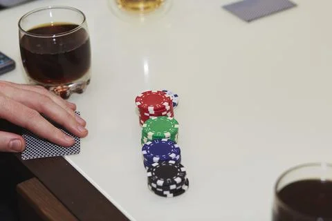 Concept of playing poker on the table with chips and cards. A glass of whiskey Stock Photos