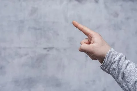 Concept of pointing finger. Close-up of a man in a sweater pointing his finge Stock Photos