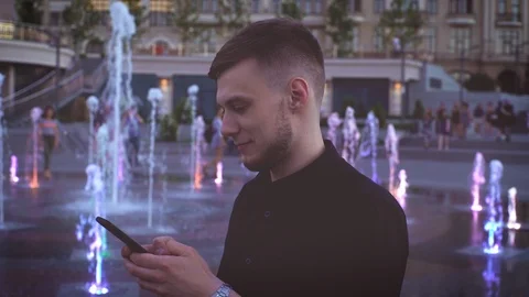 Concept portrait of young man using his smartphone in beatiful city downtown in Stock Footage 117621518