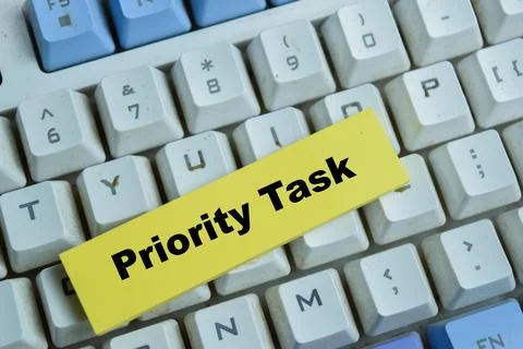 Concept of priority task write on sticky notes isolated on Wooden Table. Stock Photos