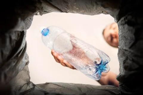 Concept of the problem of plastic waste disposal. A man throws an old used bo Stock Photos