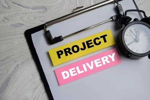 Concept of project delivery write on sticky notes isolated on Wooden Table. Stock Photos