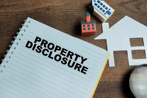Concept of property disclosure write on book isolated on Wooden Table. Stock Photos