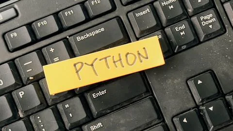 Concept of Python write on sticky notes isolated on Wooden Table. Stockfoto's