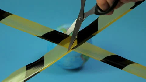 Concept: quarantine end. Hand with scissors cuts a black-yellow ribbon. Stock Footage 130711942