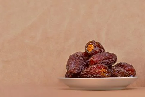 The Concept Of Ramadan. Dates in a plate on a light beige background Stock Photos
