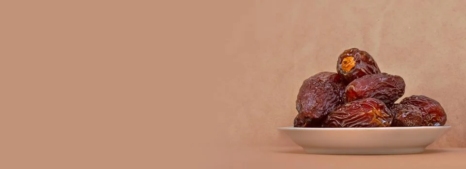 The Concept Of Ramadan. Dates in a plate on a light beige background Stock Photos