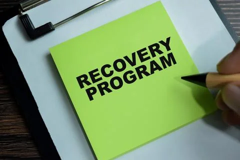 Concept of recovery program write on sticky notes isolated on Wooden Table. Stock Photos